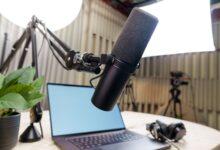 Professional podcast studio setup featuring a microphone, laptop, and headphones ready for recording.