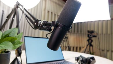 Professional podcast studio setup featuring a microphone, laptop, and headphones ready for recording.