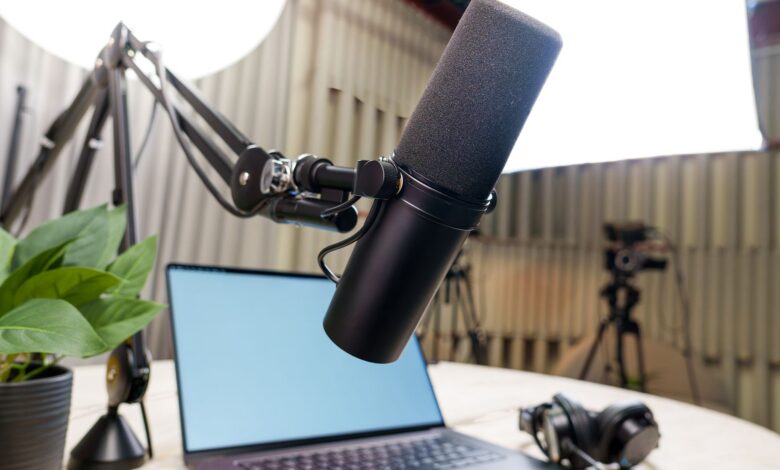 Professional podcast studio setup featuring a microphone, laptop, and headphones ready for recording.