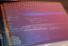Focused view of a computer screen displaying programming code with visible reflections.