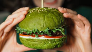 A delectable green veggie burger held in hands, perfect for healthy eating enthusiasts.
