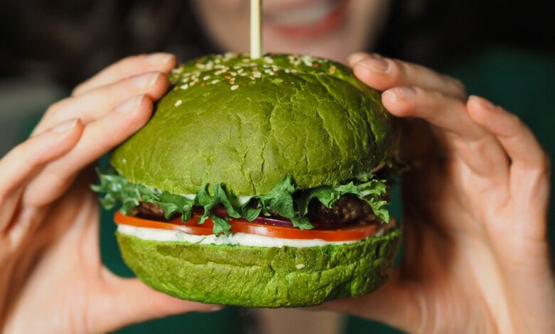 A delectable green veggie burger held in hands, perfect for healthy eating enthusiasts.