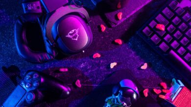 Colorful flat lay of gaming gear including headset, controller, and keyboard under vibrant lighting.