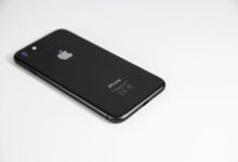 Black smartphone placed on a clean white surface, highlighting modern design and tech elegance.