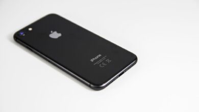 Black smartphone placed on a clean white surface, highlighting modern design and tech elegance.