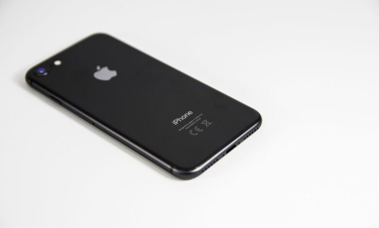 Black smartphone placed on a clean white surface, highlighting modern design and tech elegance.