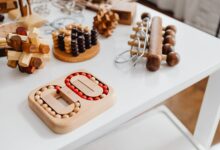 A collection of wooden brain teasers and puzzles on a table, showcasing various designs and structures.