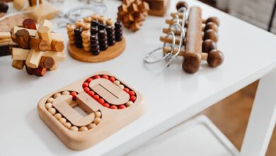 A collection of wooden brain teasers and puzzles on a table, showcasing various designs and structures.