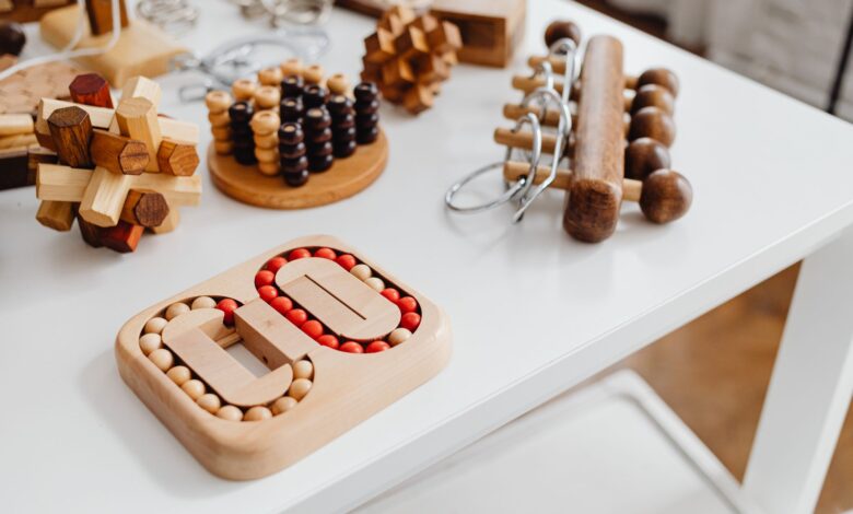 A collection of wooden brain teasers and puzzles on a table, showcasing various designs and structures.