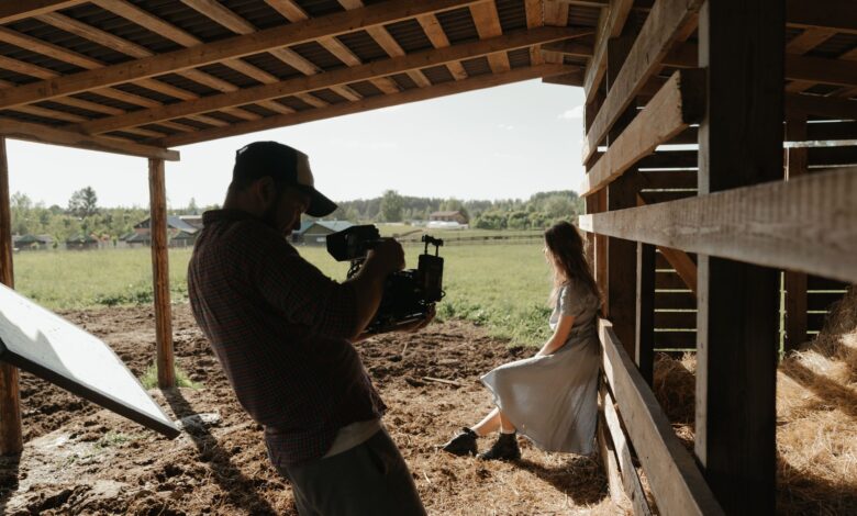 A filmmaker captures a serene scene in a rustic barn setting, outdoors.