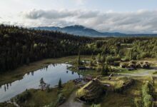 A stunning aerial view of Hemsedal, Norway, featuring tranquil lakes, forests, and traditional houses.