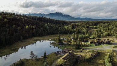 A stunning aerial view of Hemsedal, Norway, featuring tranquil lakes, forests, and traditional houses.