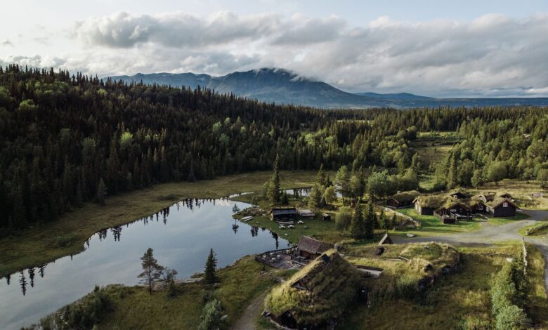 A stunning aerial view of Hemsedal, Norway, featuring tranquil lakes, forests, and traditional houses.