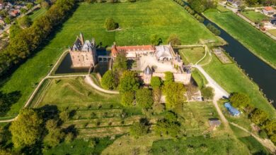 A stunning aerial view of a historic castle surrounded by lush greenery and farmland.
