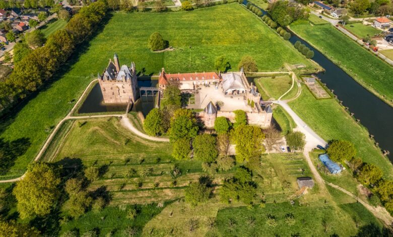 A stunning aerial view of a historic castle surrounded by lush greenery and farmland.