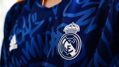 Detailed view of a blue soccer jersey featuring a prominent club emblem, ideal for sports branding.