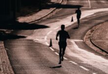 Silhouette of a runner on a street during a race. Captures athletic determination and movement.