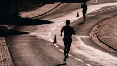Silhouette of a runner on a street during a race. Captures athletic determination and movement.