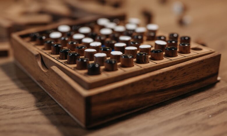 Detailed view of a wooden board game with black and white pieces, symbolizing strategy and leisure.