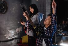 Two friends have fun playing a guitar simulation game indoors.