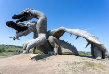 Impressive dragon sculpture outdoors on a sunny day, offering a captivating view.