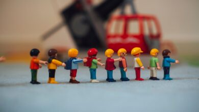Miniature plastic figures lined up in front of a toy helicopter, creating a playful scene.