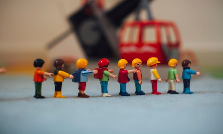 Miniature plastic figures lined up in front of a toy helicopter, creating a playful scene.