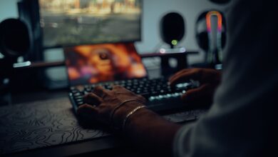Focused man typing in a dimly lit room, creating a moody atmosphere.