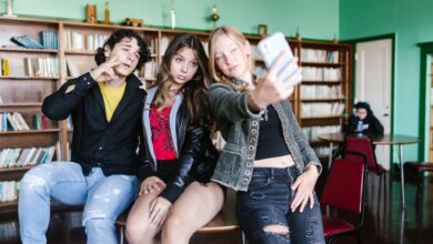 Group of teenagers taking a selfie in a school library, showcasing friendship and fun.