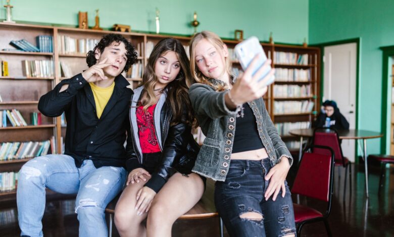 Group of teenagers taking a selfie in a school library, showcasing friendship and fun.