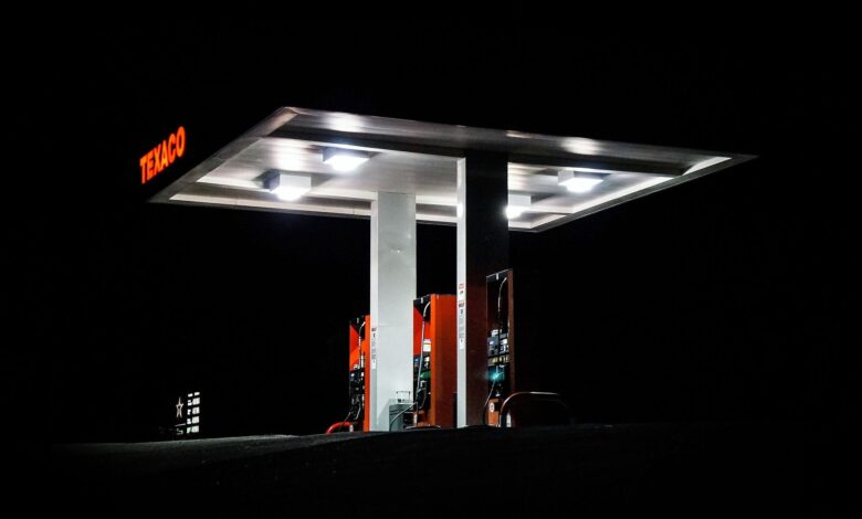 Night view of a Texaco gas station brightly illuminated with fuel pumps visible against a dark backdrop.