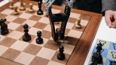Robotic arm playing a strategic chess game on a wooden board, showcasing technology and innovation.