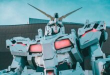 Striking view of a giant robot sculpture with vibrant LED accents in an urban setting.