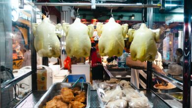 A vibrant display of rotisserie chickens in a Thai street market booth.