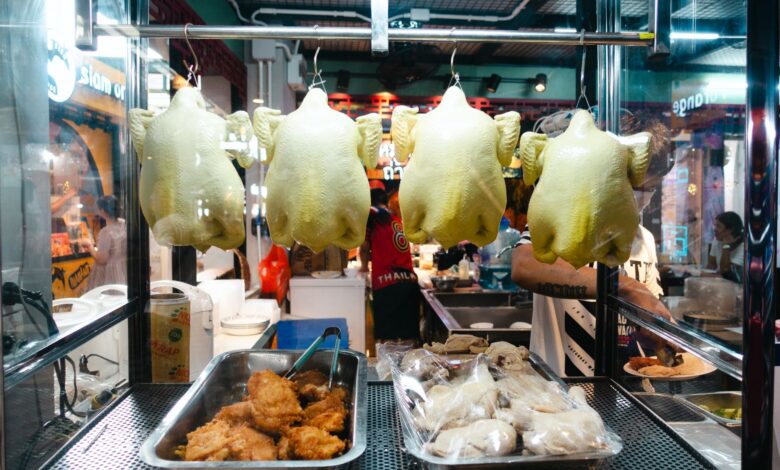 A vibrant display of rotisserie chickens in a Thai street market booth.