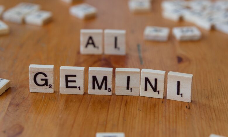 Scrabble tiles spell out the words 'Gemini' and 'AI' on a wooden surface, symbolizing technology and communication.