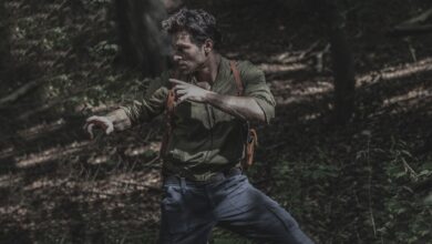 A man engages in martial arts practice amidst a dense forest environment, showcasing survival skills.