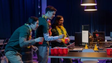 Group of male colleagues enjoying a fun beer pong game during an office party night.