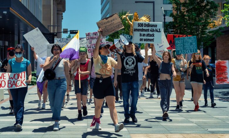 Women leading a vibrant protest for empowerment and social justice in an urban setting.