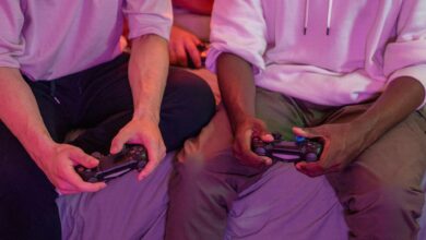 Two friends playing video games together at home, using controllers.