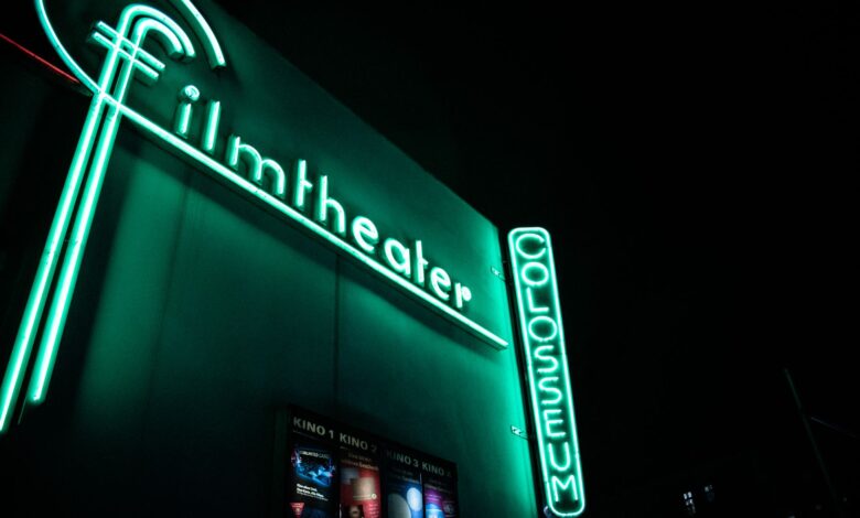 Vibrant neon film theater sign glowing at nighttime.