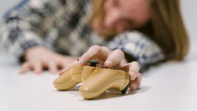 Hand reaching out to touch a yellow game controller, focus on interaction.