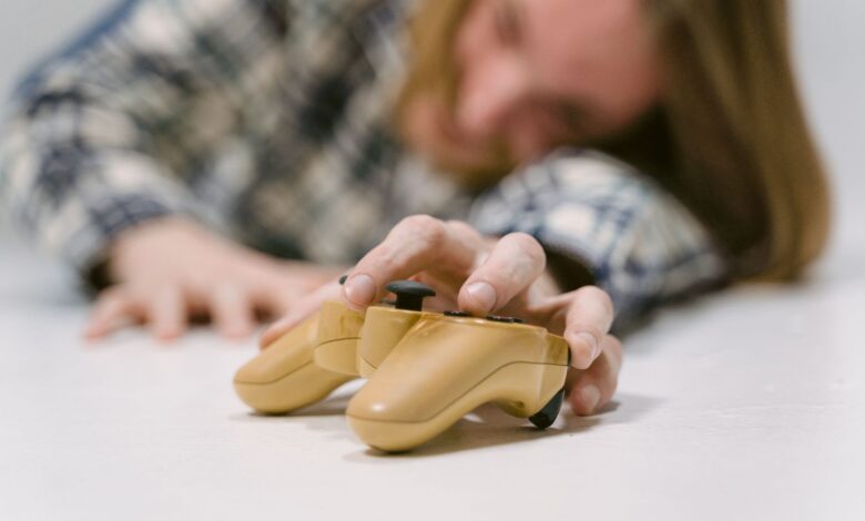 Hand reaching out to touch a yellow game controller, focus on interaction.