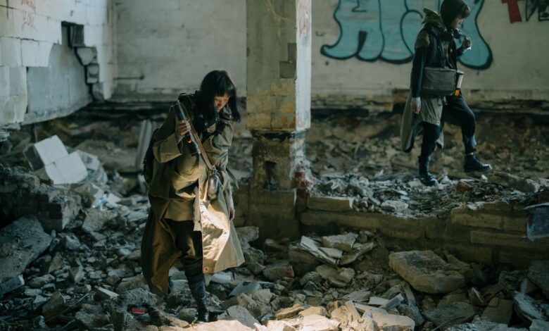 Two people exploring a desolate, abandoned building, embodying a post-apocalyptic theme.