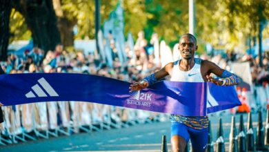 Male athlete crossing the finish line at the Buenos Aires marathon in a lively outdoor event.