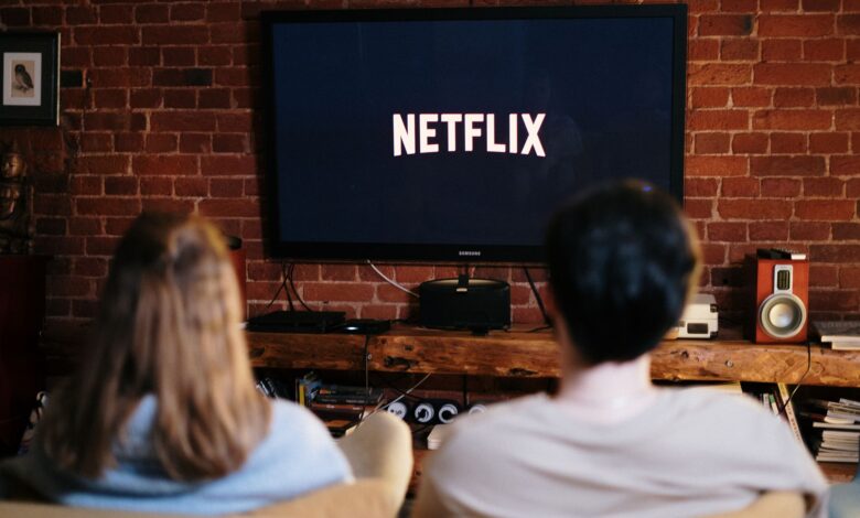 A couple relaxing and watching Netflix in a cozy living room setting.