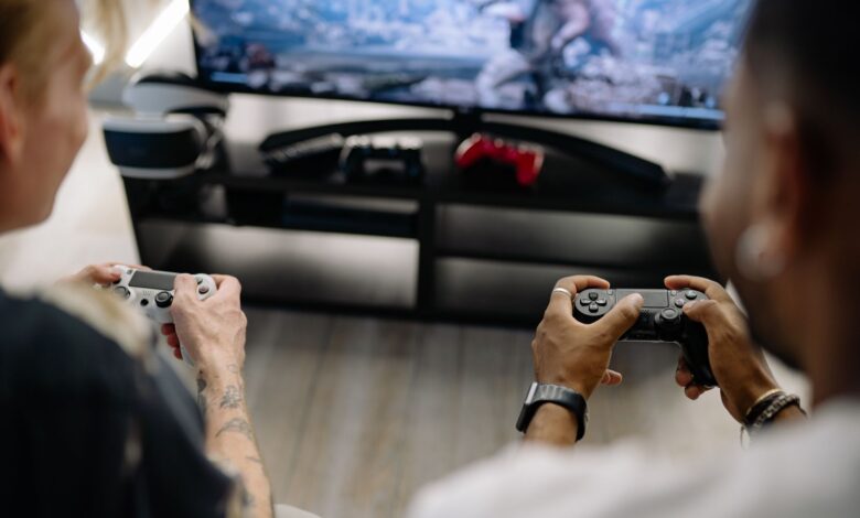Two friends enjoying a video game session indoors using controllers, focusing on teamwork and fun.