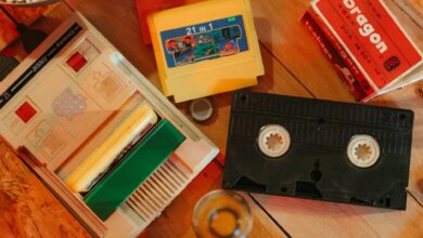 Vintage gaming console with cartridges and VHS tape on wooden surface, nostalgic theme.