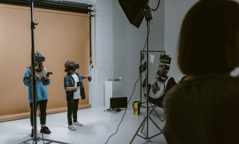Two kids experience virtual reality gaming in a professional studio setting with VR headsets and controllers.