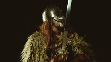 A Viking warrior in armor holding a sword, showcasing historical attire.